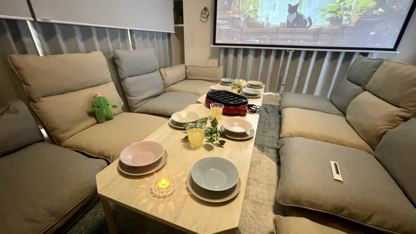 お気軽スペースAMAN2号店の映画モード。大型スクリーンに映像を映し、テーブルにはキャンドルとたこ焼き器
